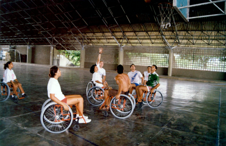 Basquete com participantes  do projeto para pessoas com deficiência “Amigos especiais da UFPE” na quadra do Núcleo de Educação Física e Desportos (NEFD) nos anos 90.